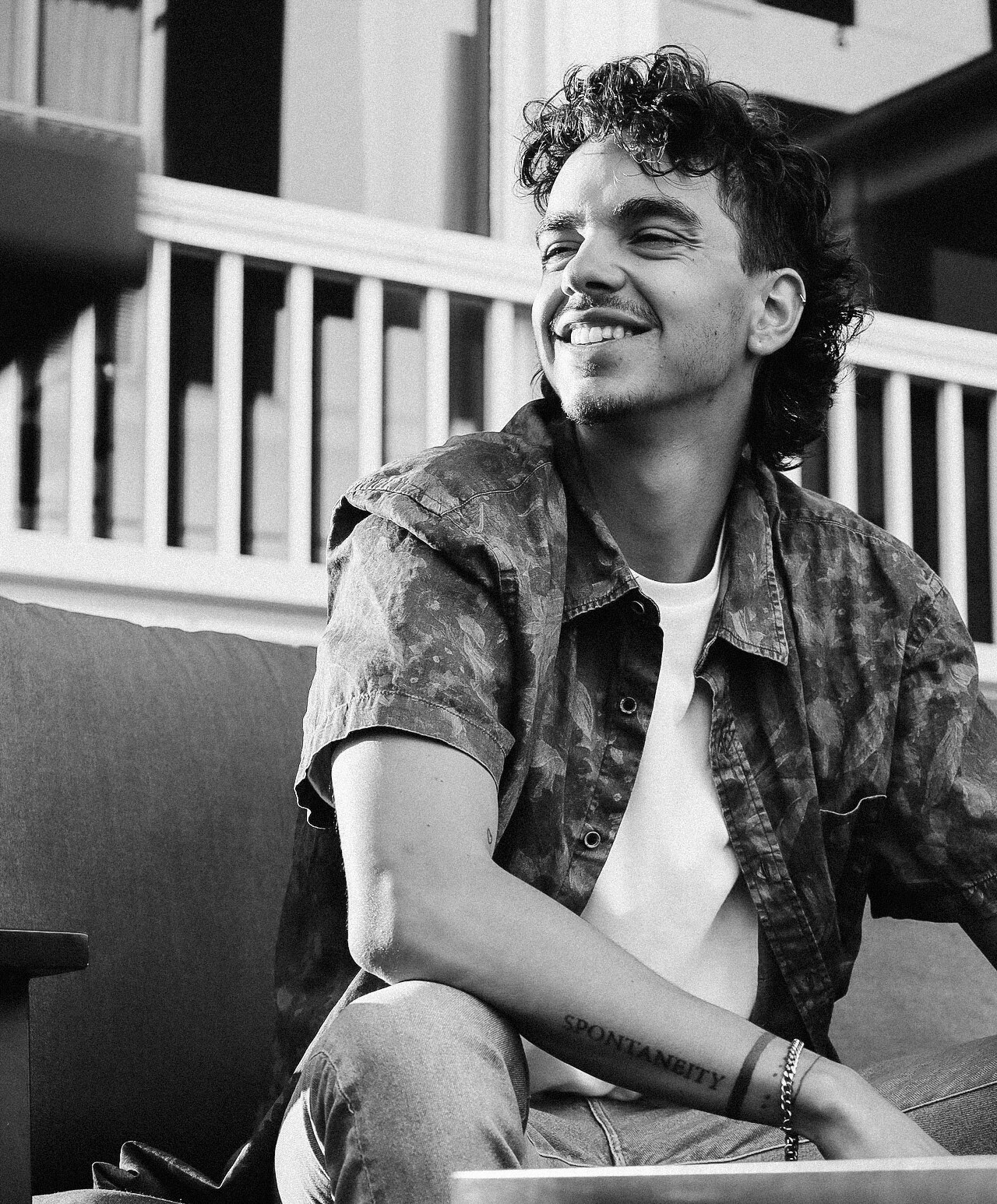 Sage Smith portrait, smiling, seated outdoors